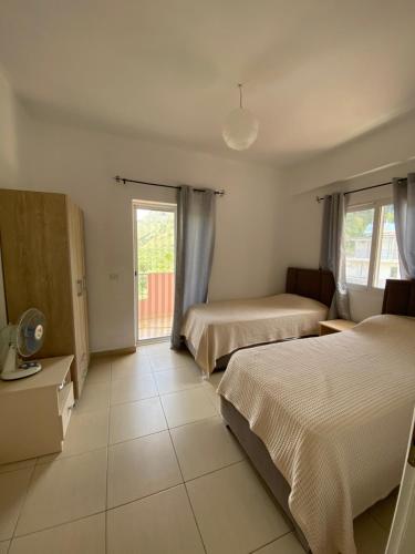 a hotel room with two beds and a window at Gkiko’s Guest House in Qeparo