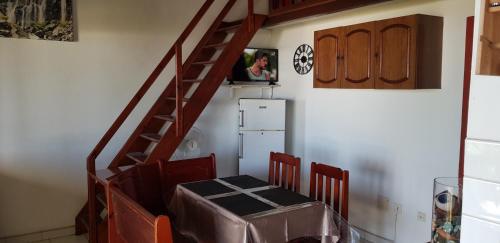 a room with a staircase with a table and a refrigerator at Locations Alpinia Réunion in Saint-Paul