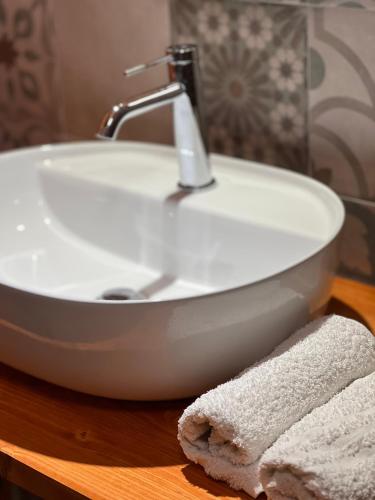 a white sink on a wooden table with a towel at GarganoMareBorghi ospitalità diffusa in Vico del Gargano