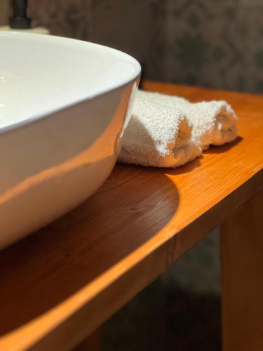 a white bowl on a wooden table with a piece of bread at GarganoMareBorghi ospitalità diffusa in Vico del Gargano