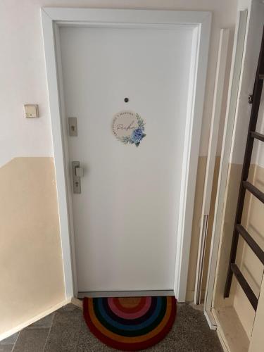 a white door in a room with a colorful rug at Luxury Apartment PECKA in city centre in Martin