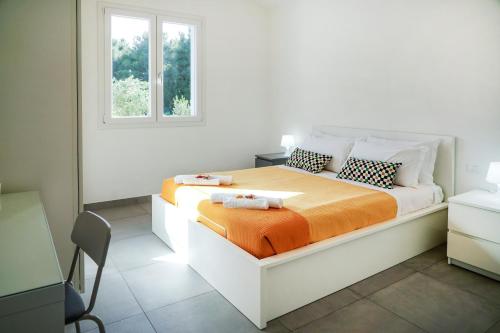 1 dormitorio blanco con 1 cama con manta naranja en Luxury Villa La Perla - Castellammare del golfo with Pool, Garden and Parking, en Castellammare del Golfo