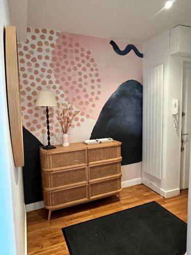 a room with a dresser and a wall with a mural at COEUR DE BLOIS CHARMANT APPART LOUIS XII VUE LOIRE in Blois