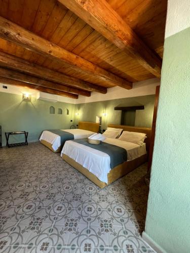 2 Betten in einem Zimmer mit Holzdecken in der Unterkunft GarganoMareBorghi ospitalità diffusa in Vico del Gargano