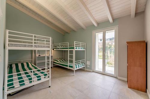 a room with three bunk beds and a window at Charming one-floor villa with garden, car parking in Albisola Superiore