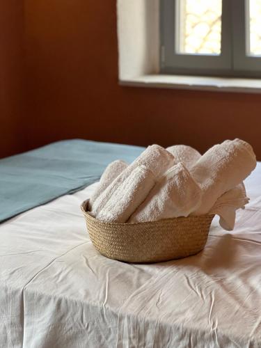 a basket of towels sitting on top of a bed at GarganoMareBorghi ospitalità diffusa in Vico del Gargano