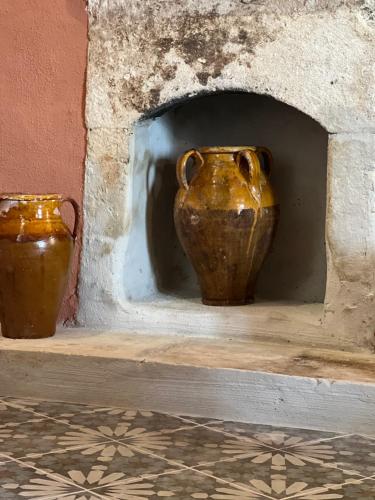 two vases sitting on a shelf in a wall at GarganoMareBorghi ospitalità diffusa in Vico del Gargano