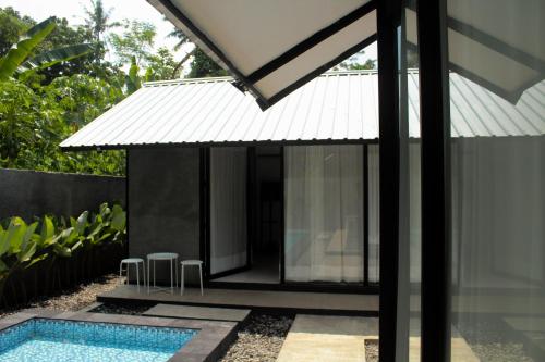 a house with a swimming pool next to a building at Niti Bhumi Villa in Borobudur