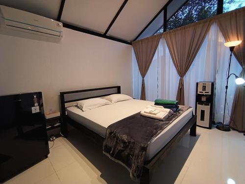 a bedroom with a bed and a large window at Niti Bhumi Villa in Borobudur