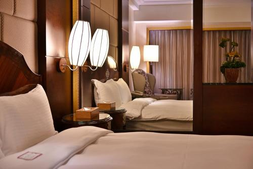 a hotel room with two beds and a mirror at Waikoloa Hotel in Taipei
