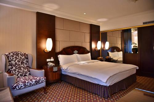 1 dormitorio con 1 cama grande y 1 silla en Waikoloa Hotel, en Taipéi