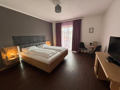 um quarto de hotel com uma cama e uma televisão em Pension Hoogerland em Velden am Wörthersee