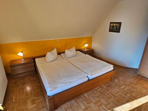 a bedroom with a bed with two lamps on both sides at Gästehaus Grunewald Bed & Breakfast in Heiden