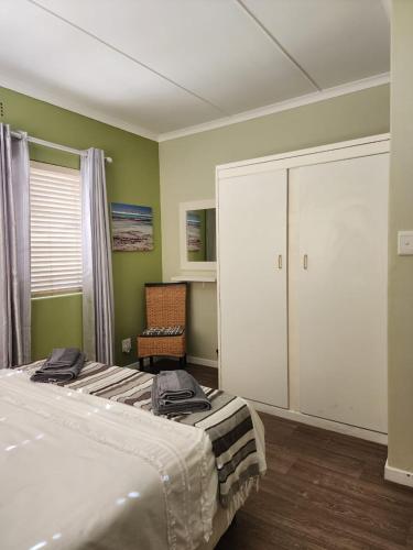 a bedroom with two beds and a sliding door at 16 on Main Arniston PET-FRIENDLY in Arniston
