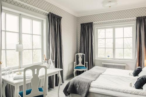 a bedroom with a bed and a desk and two chairs at Rimforsa Strand in Rimforsa