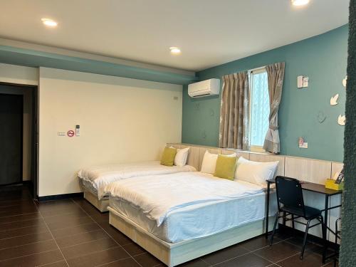 a bedroom with a bed and a desk in it at 玩轉金門民宿2館-樂遊小鎮民宿 in Jincheng