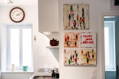 a kitchen with two pictures on the wall and a clock at Casa In Contrada by Quokka 360 - Village life and lake in Bissone