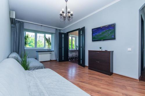 1 dormitorio con 1 cama y TV en la pared en Seven en Vyshneve