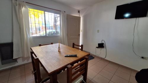 ein Esszimmer mit einem Holztisch und einem TV in der Unterkunft Alquiler de departamento por día excelente ubicacion in Neuquén