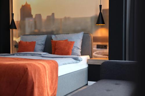 ein Schlafzimmer mit einem Bett mit orangefarbenen Kissen und einem Fenster in der Unterkunft JustStay Essen in Essen