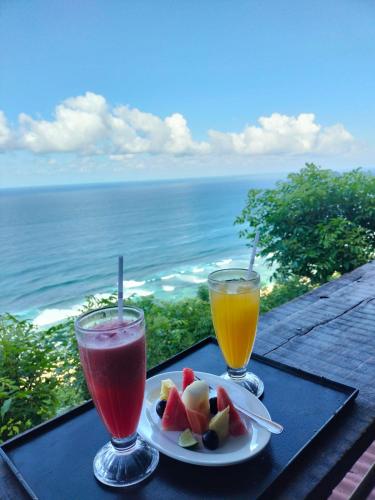 two drinks and a plate of fruit on a table at Nunggalan Octopus 1 in Uluwatu