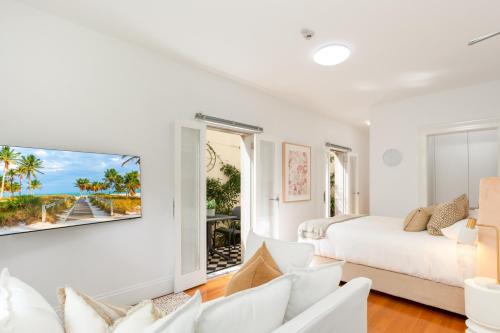 een witte kamer met een bed en uitzicht op de oceaan bij Cosy Inner West Studio with Courtyard in Sydney