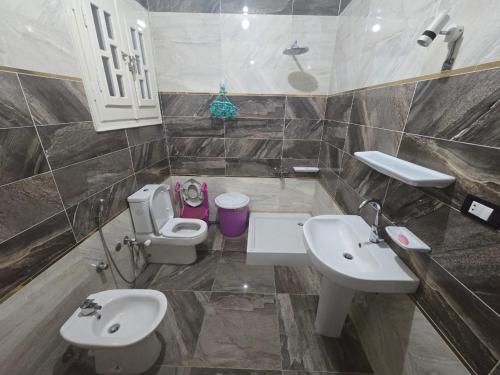 uma casa de banho com 2 lavatórios, um WC e um espelho. em sunwing pyramids view em Al Mahallah Al Kubra