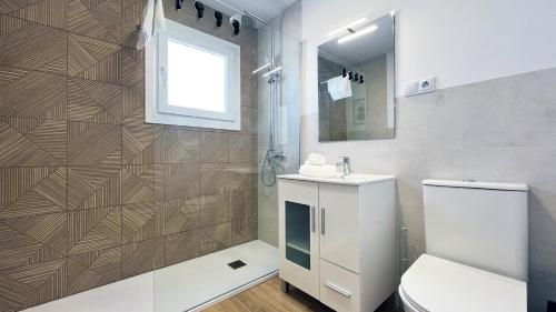 Un baño con inodoro, lavabo y ducha. en Mshome Beach Haven, en Torre de Benagalbón