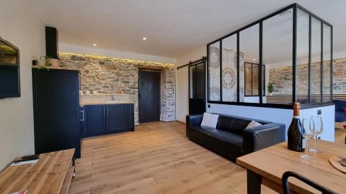 un salon avec un canapé et une table dans l'établissement Le Relais de Diligence Balnéo & Sauna, à Salsigne