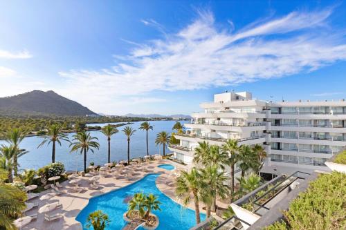 an image of a resort with a pool and palm trees at VIVA Eden Lago in Port d'Alcudia