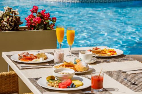 una mesa con platos de comida y dos vasos de zumo de naranja en VIVA Sunrise, en Puerto de Alcudia