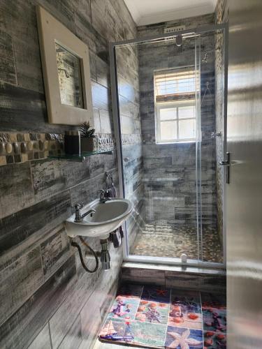 a bathroom with a sink and a shower at 16 on Main Arniston PET-FRIENDLY in Arniston