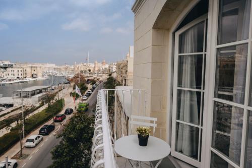a balcony with a table and a view of a city at Dock 1 Boutique Hotel in Cospicua