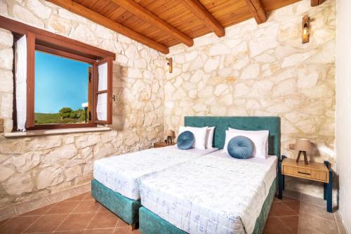 een slaapkamer met een bed in een stenen muur bij Villa Artemisia by Villa Plus in Ágios Nikólaos