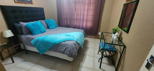 una camera da letto con un letto con cuscini blu di 20 Pendleberry Holiday Resort a Bela-Bela