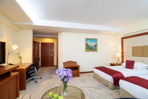 a hotel room with a bed and a desk at Kempinski Hotel Khan Palace in Ulaanbaatar