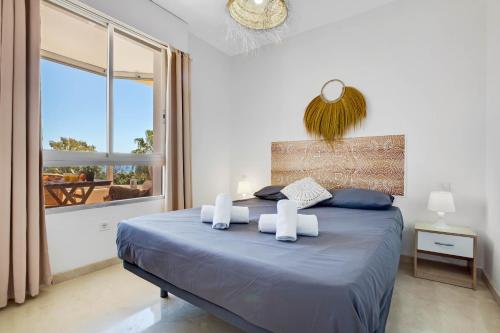 - une chambre avec un lit bleu et une grande fenêtre dans l'établissement Vistamarina 403A By IVI Real Estate, à Torremolinos