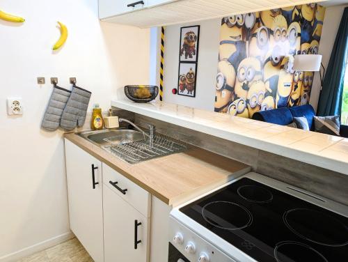 a small kitchen with a sink and a stove at Le Repaire - 10min Disney - Familial - Centre Ville in Bailly-Romainvilliers