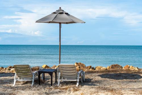 two chairs and an umbrella on the beach at Koh Chang Longstay Resort in Ko Chang