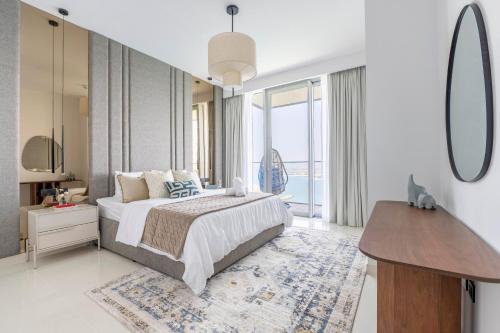 a bedroom with a bed and a dresser and a mirror at 2BR Beachfront Gem with Dazzling Views of the Palm in Dubai