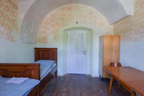 una camera con due letti e un tavolo e una porta di Ubytovanie v Kláštore - Hostel a Rožňava