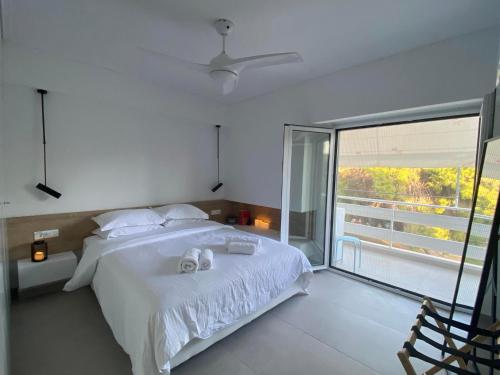 a bedroom with a white bed and a large window at Miliannas in Athens