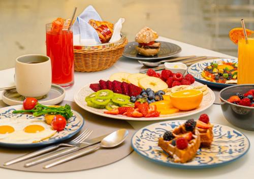 a table with plates of breakfast foods and drinks at Fairmont Doha in Doha
