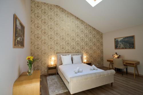 A bed or beds in a room at Les Appartements de la Cadène
