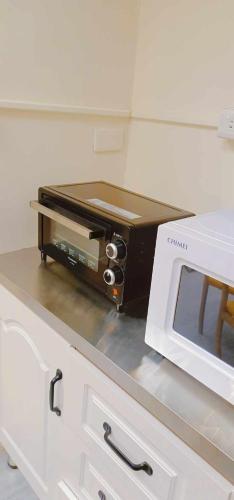 a toaster oven sitting on a counter next to a microwave at yourcity 台北101 和 大巨dome旁邊 大空間睡8人 in Taipei