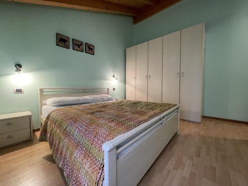 a bedroom with a large bed and a white cabinet at Residence Valentino in Pinzolo