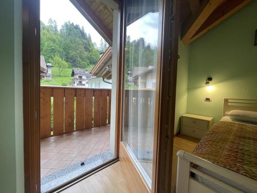 a bedroom with a large glass door leading to a balcony at Residence Valentino in Pinzolo