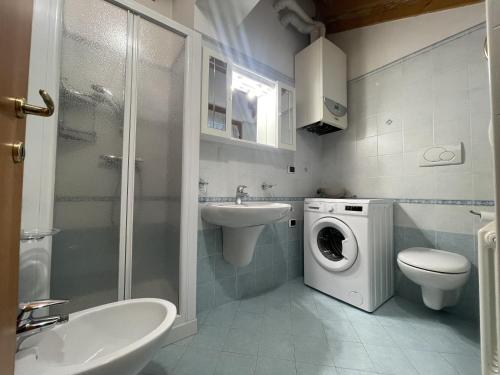 a bathroom with a sink and a washing machine at Residence Valentino in Pinzolo