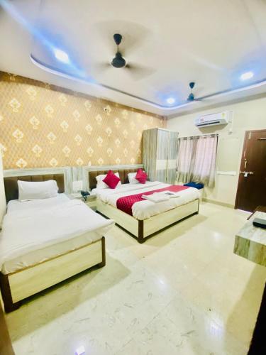 two beds in a bedroom with a ceiling at Hotel vinayak in Indore