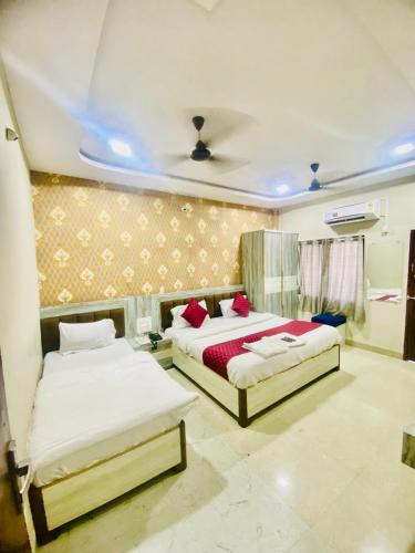 a bedroom with two beds and a ceiling at Hotel vinayak in Indore